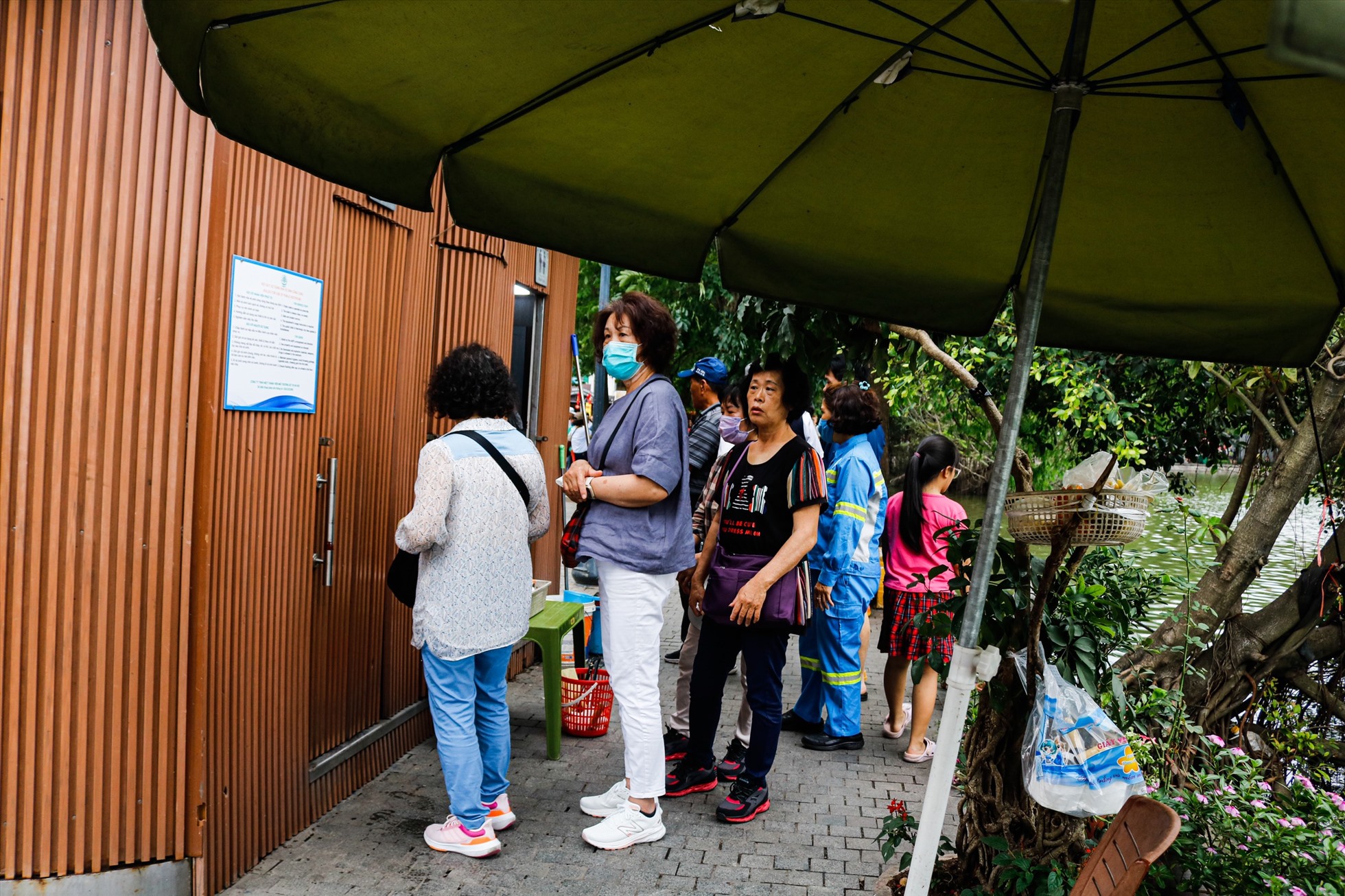 Hàng dài du khách xếp hàng đi nhà vệ sinh công cộng trên phố đi bộ Hồ Gươm. Ảnh: Thu Hiền