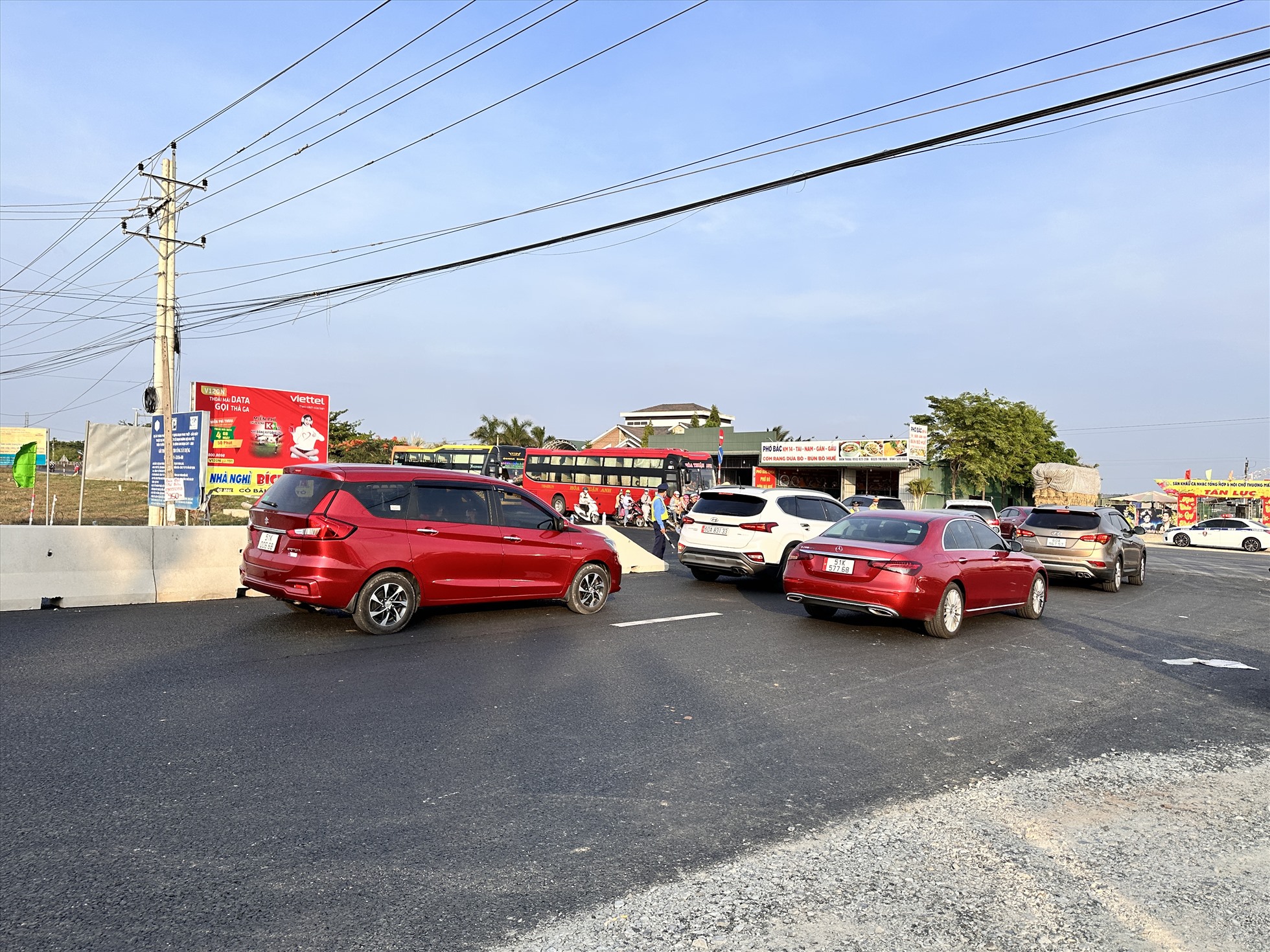 Các phương tiện đi ra từ hướng cao tốc băng qua QL1 để đi về hướng Phan Thiết rất đông nên việc chạy cắt ngang đường đã làm ùn tắc 2 chiều xe trên QL1. Ảnh: Duy Tuấn