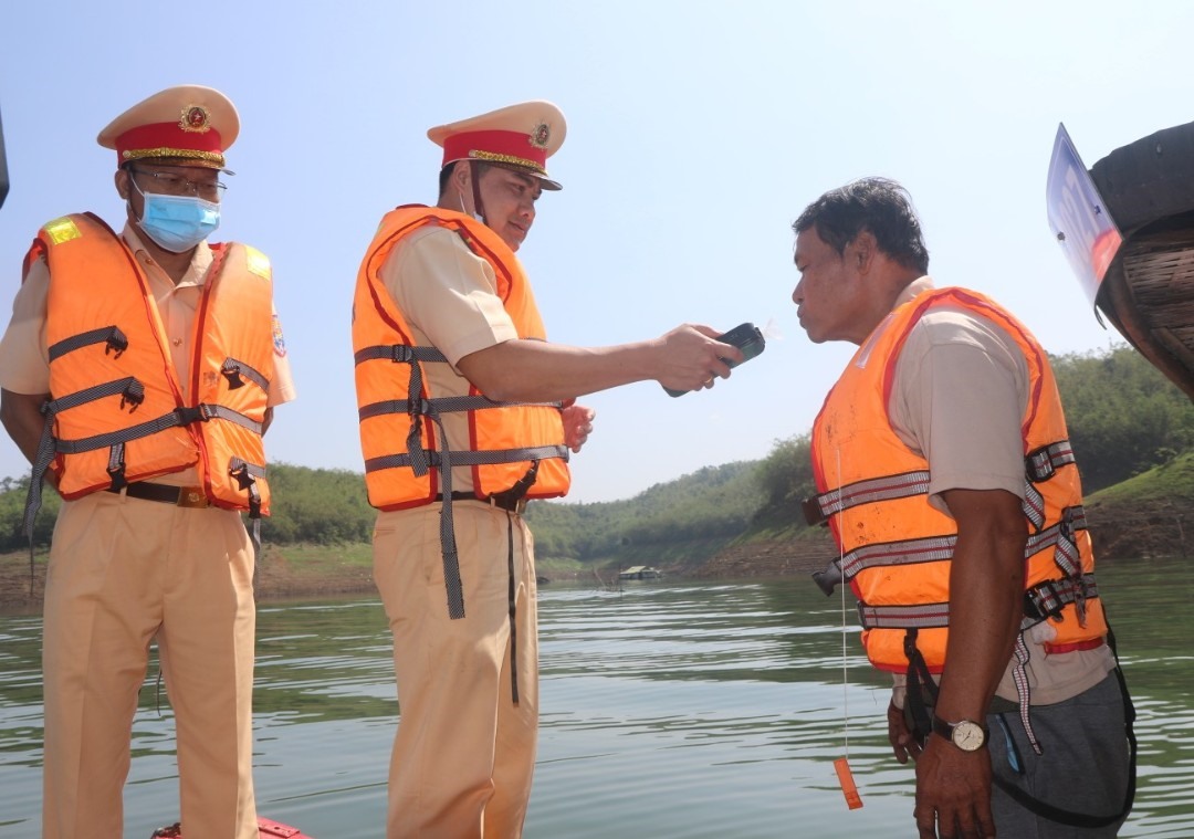 Lực lượng Cảnh sát giao thông kiểm tra nồng độ cồn đối với người lái thuyền ở “Vịnh Hạ Long” trên cao nguyên. Ảnh: Minh Quỳnh