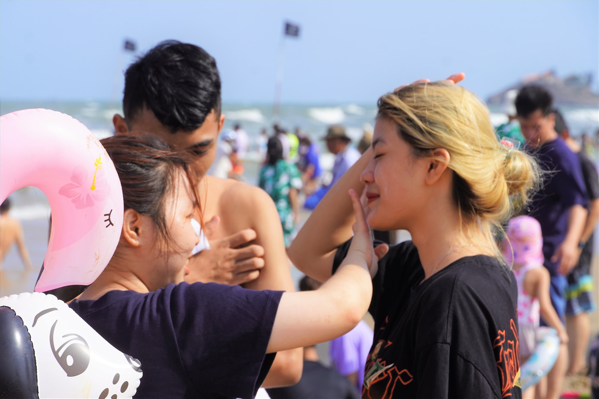 Nhiều du khách nữ thoa kem để bảo vệ làn da trước ánh nắng khá gay gắt khi xuống biển. Ảnh: Thành An