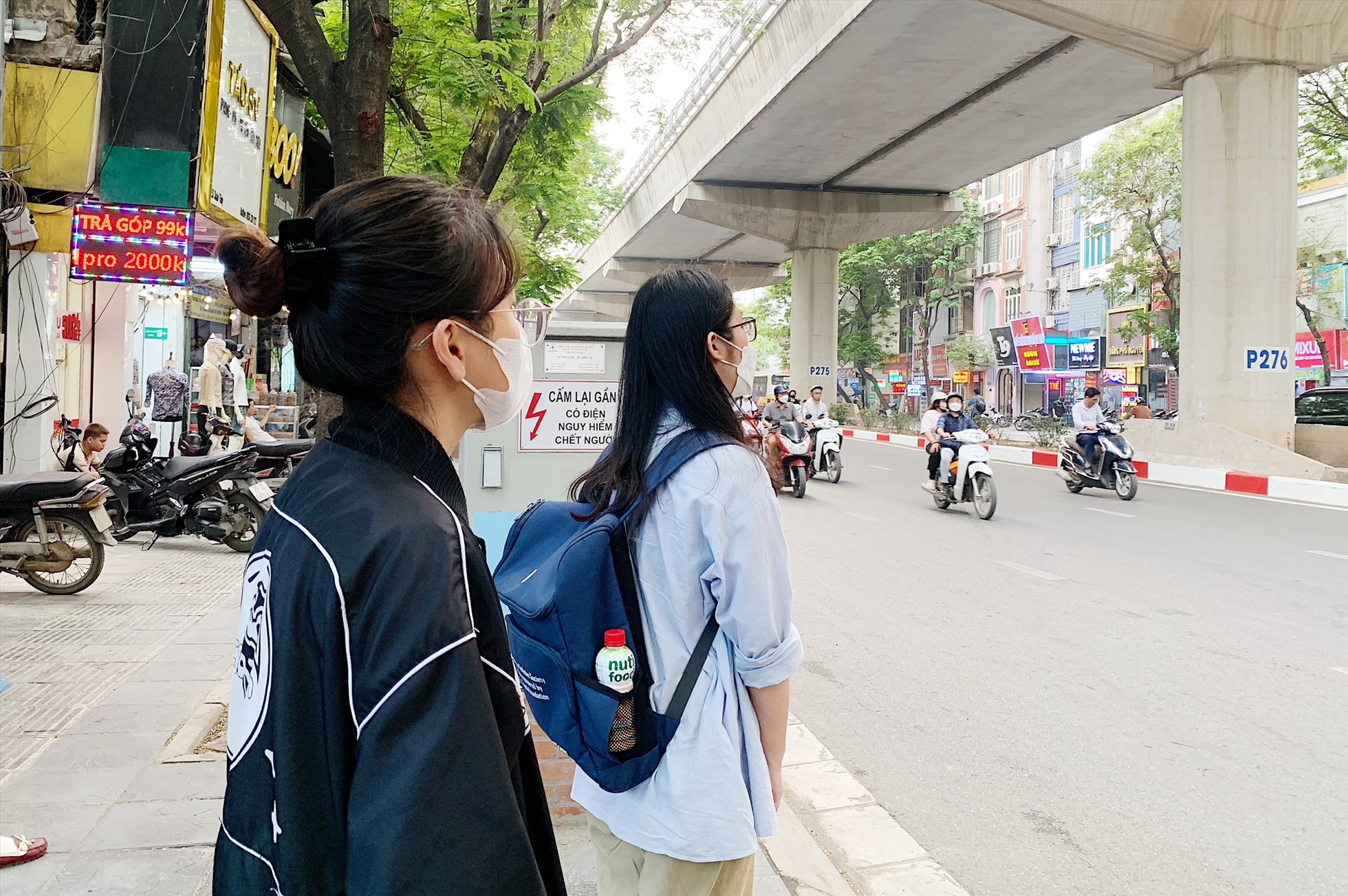 Chị Trần Thanh Vân tập trung nhìn xe buýt đến vì sợ bỏ lỡ chuyến. Ảnh: Thu Hiền