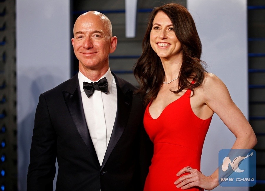 Tỉ phú Jeff Bezos - người sáng lập Amazon (vest đen) đã tụt xuống vị trí thứ 3 trong danh sách những người giàu nhất thế giới của Forbes. Ảnh: Xinhua