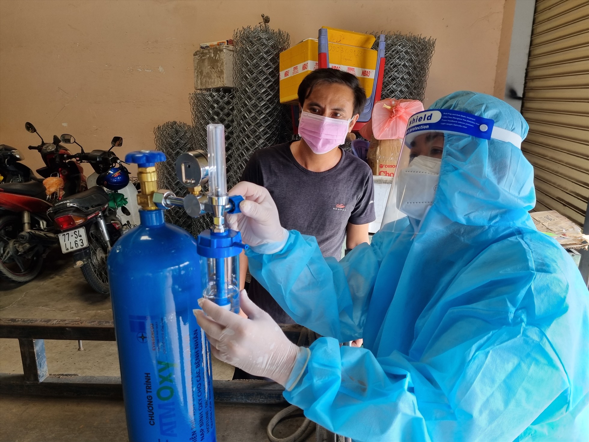 Cán bộ công đoàn EVNGENCO3, đang lắp đặt, hướng dẫn sửa dụng bình ô xy cho một gia đình có người bị mắc COVID-19 trên địa bàn Thành phố Thủ Đức, Thành phố Hổ Chí Minh thời điểm tháng 8.2021. Ảnh: Nam Dương
