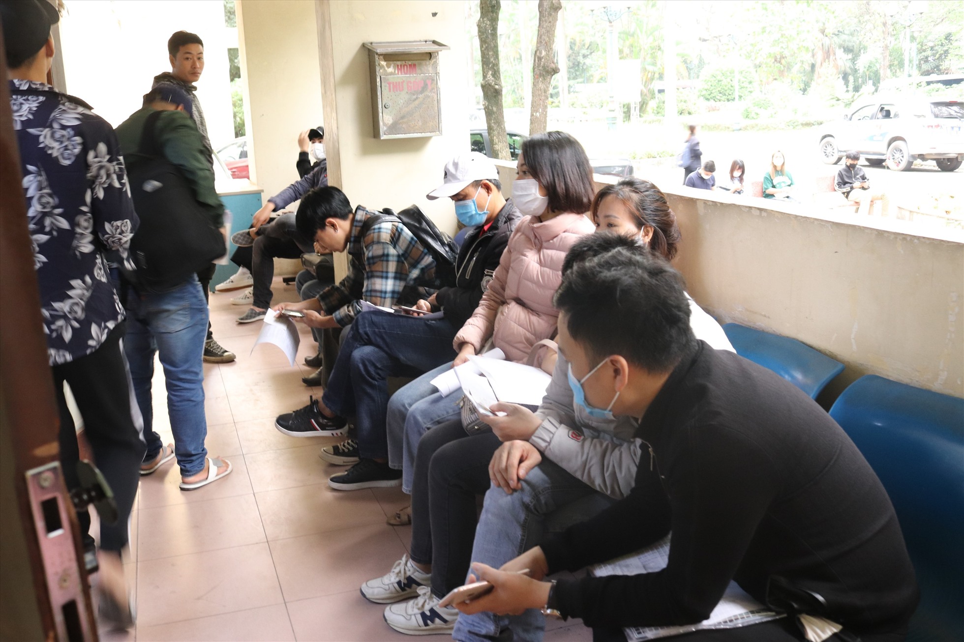 Bên ngoài hành lang, người dân ngồi kín chỗ để chờ được gọi số thứ tự vào nộp hồ sơ.