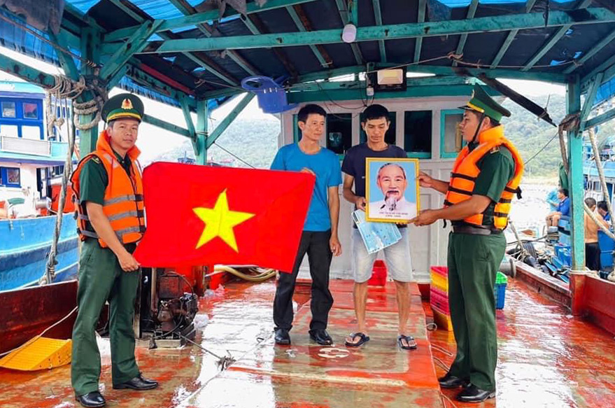 Gặp gỡ các chủ tàu đánh bắt hải sản vận động giáo dục và tặng cờ Tổ quốc. Ảnh: La Minh Nhoà