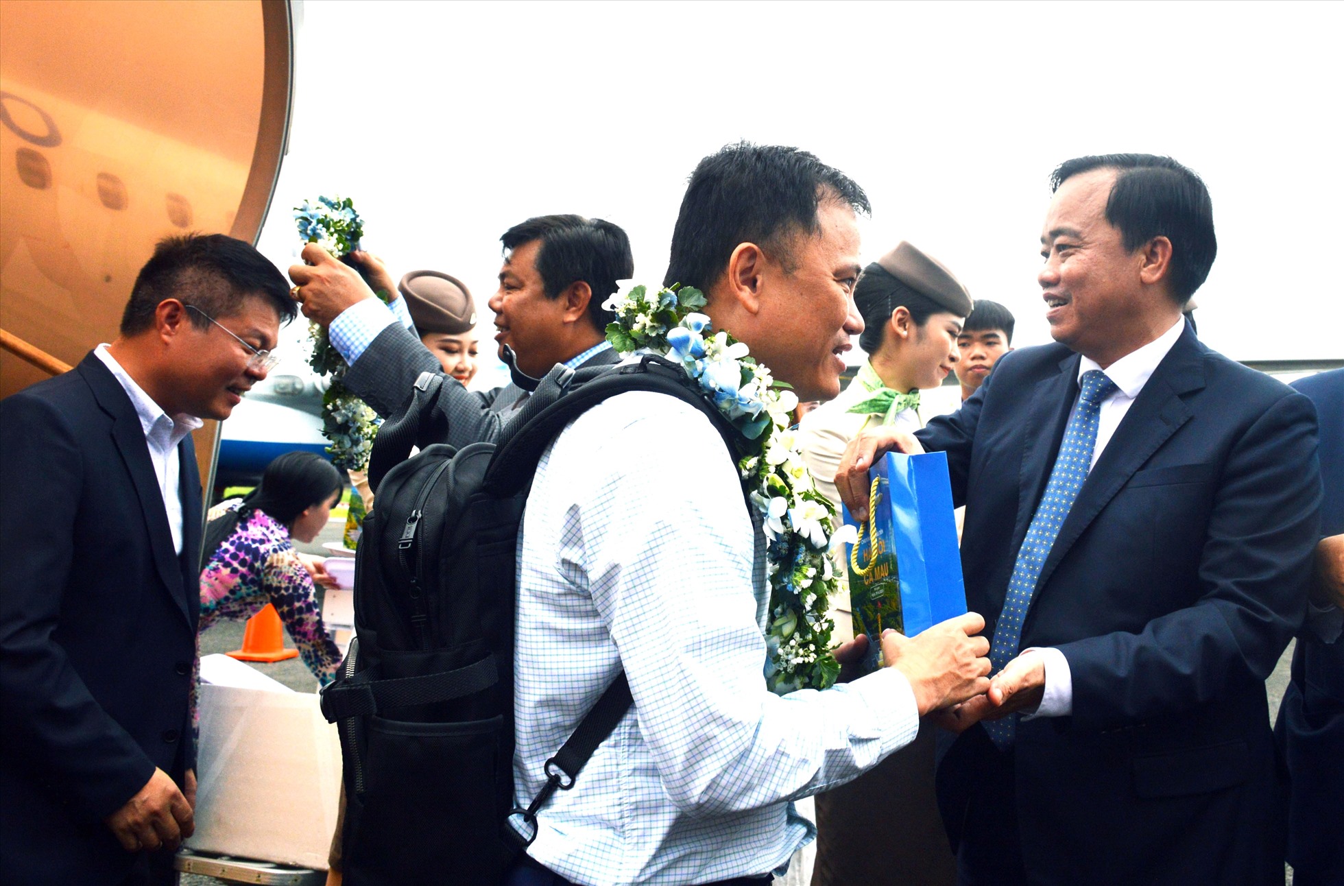 Chủ tịch UBND tỉnh Cà Mau Huỳnh Quốc Việt đón những vị khách đầu tiên trong chuyến bay thẳng Hà Nội - Cà Mau tại Cảng hàng không Cà Mau. Ảnh: Nhật Hồ