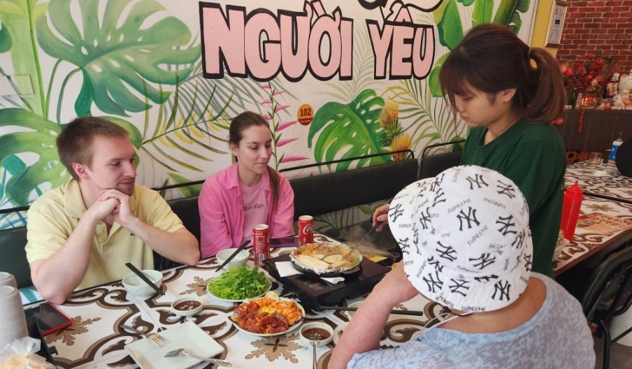 Chị Nguyễn Thị Hoa - nhân viên nhà hàng bò 888 đang phục vụ du khách nước ngoài. Ảnh: Hà Anh