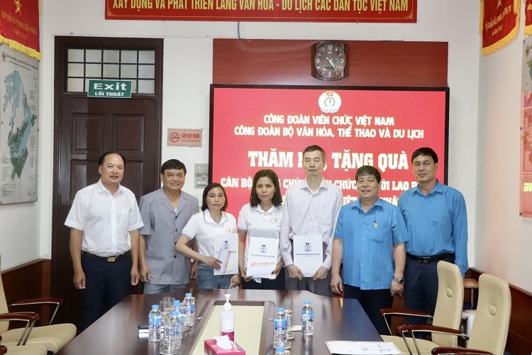 Đoàn công tác trao quà cho 3 đoàn viên (thứ tự thứ 3 từ phải sang) có hoàn cảnh khó khăn tại Công đoàn Ban Quản lý Làng Văn hoá - Du lịch các dân tộc Việt Nam. Ảnh: Tiến Dũng.