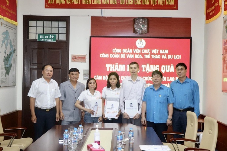 Đoàn công tác trao quà cho 3 đoàn viên (thứ 3, từ phải sang) tại Công đoàn Ban Quản lý Làng Văn hoá - Du lịch các dân tộc Việt Nam. Ảnh: Tiến Dũng