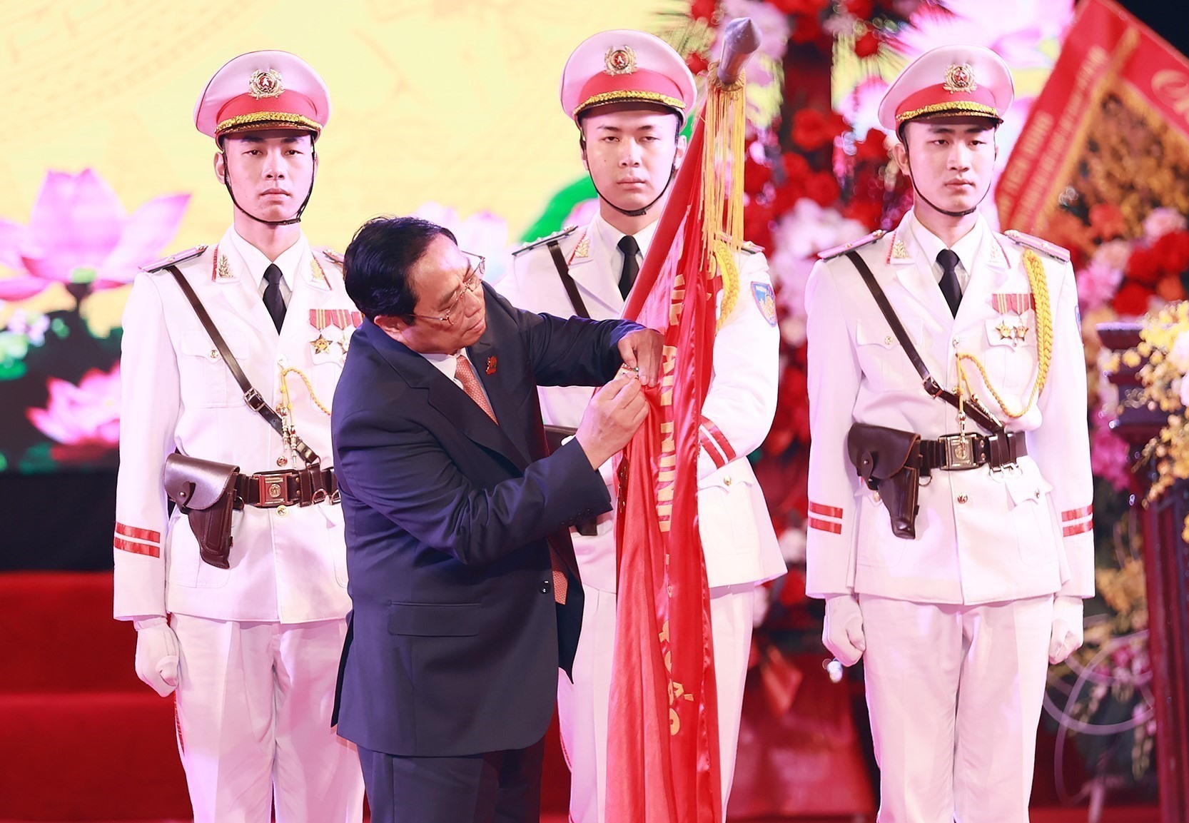 Thủ tướng Phạm Minh Chính gắn Huân chương Bảo vệ Tổ quốc hạng Nhất lên Cờ truyền thống của lực lượng An ninh Kinh tế. Ảnh: TTXVN
