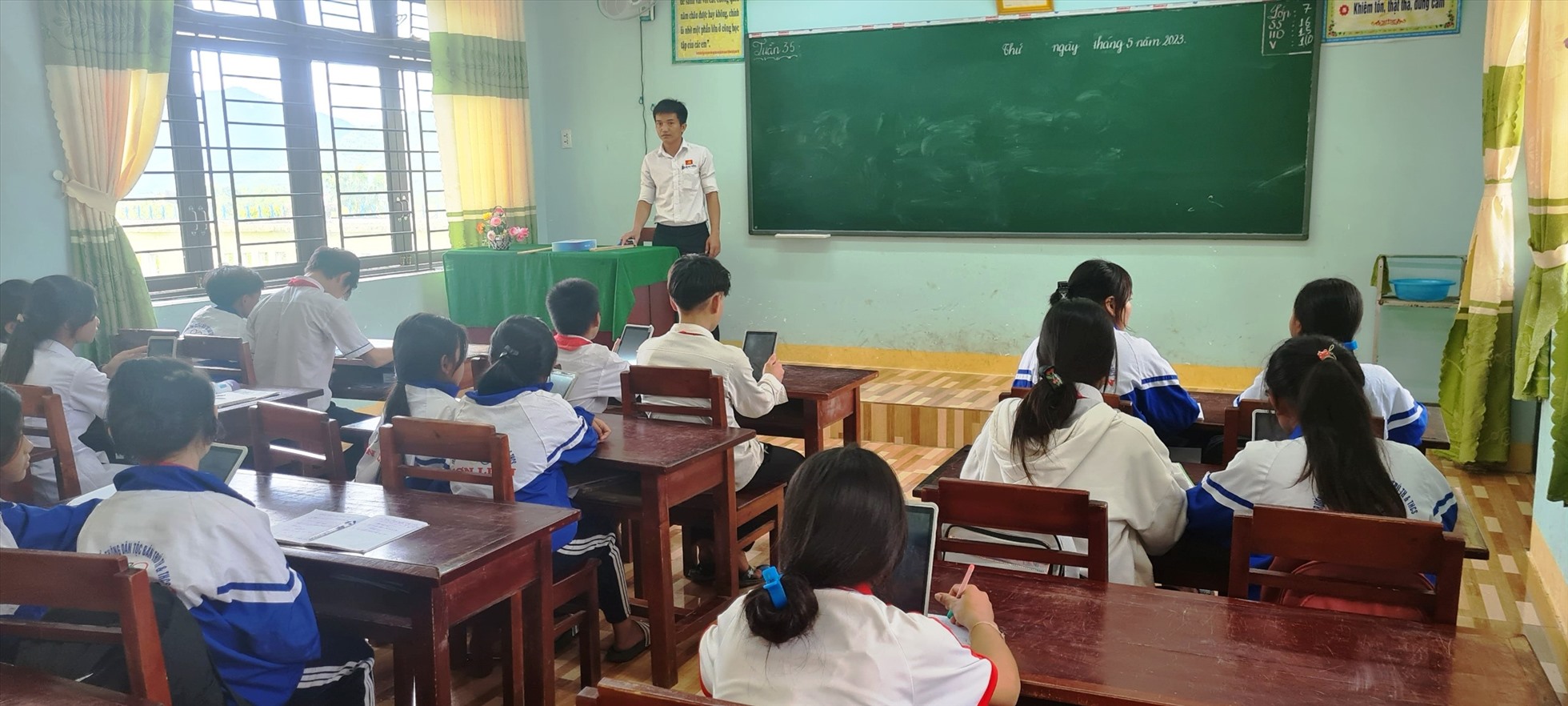 Giáo viên Trường Phổ thông dân tộc bán trú TH&THCS Sơn Liên, huyện Sơn Tây  nhắc nhở HS sử dụng máy tính bảng phục vụ trong học tập. Ảnh: Ngọc Viên