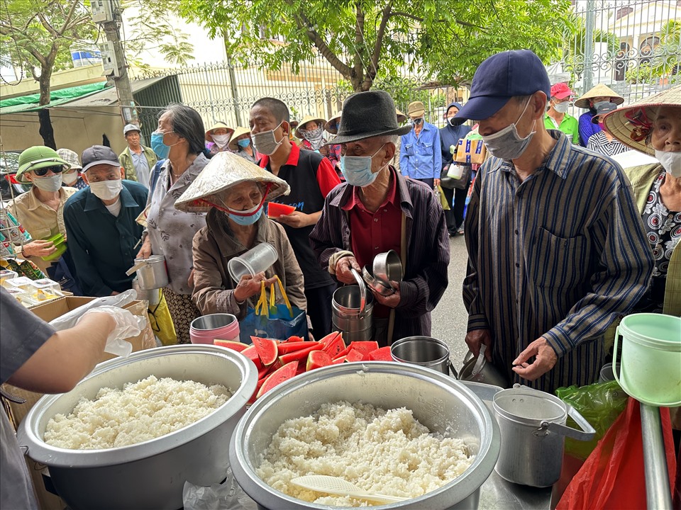 Mọi người sẽ nhận cơm qua cặp lồng được nhóm hỗ trợ để đảm bảo an toàn vệ sinh và giảm lượng rác thải ra. Ảnh: Hương Lê