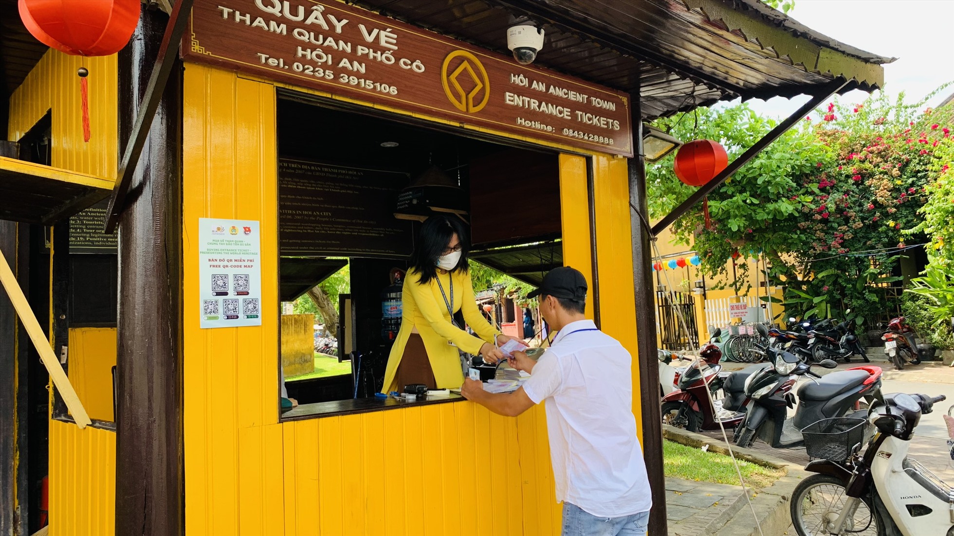 Hướng dẫn viên du lịch mua vé cho đoàn khách tham quan vào phố cổ Hội An tại điểm bán vé gần quảng trường sông Hoài. Ảnh Hoàng Bin
