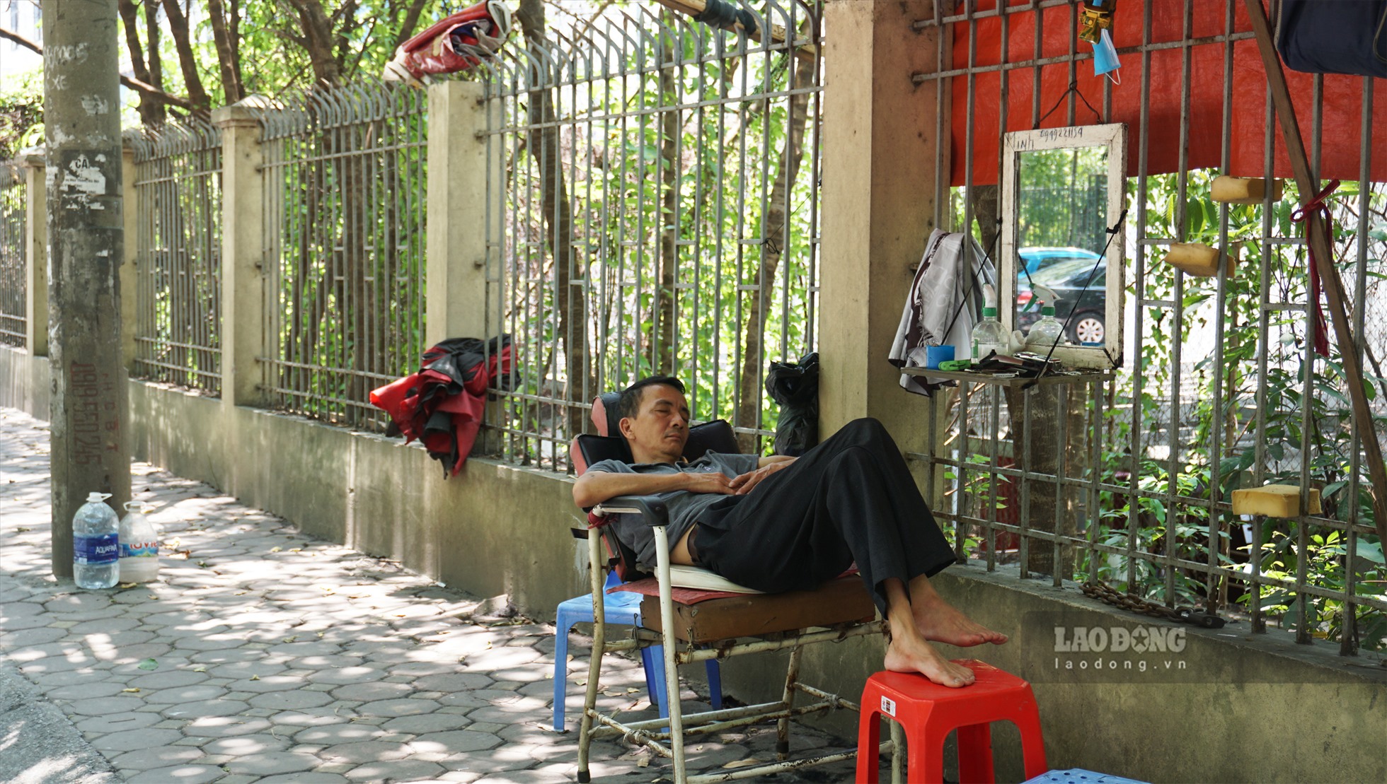 Một người lao động cũng chọn cho mình một giấc ngủ trưa trên ghế cắt tóc  tại đường Hoàng Hoa Thám (quận Ba Đình).