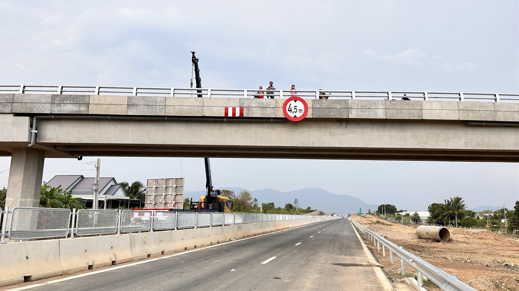 Người dân đứng trên cầu vượt để xem đường cao tốc.