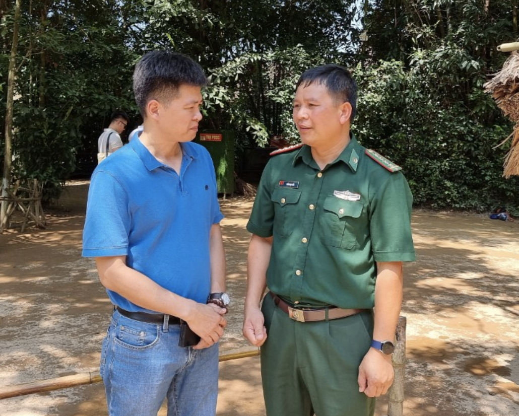 Nhà báo Hoàng Lâm - Báo Lao Động trao đổi với Đại tá Trần Ngọc Ước - cán bộ của Bộ Chỉ huy Bộ đội Biên phòng tỉnh Lào Cai tại làng Sen. Ảnh: Quang Đại