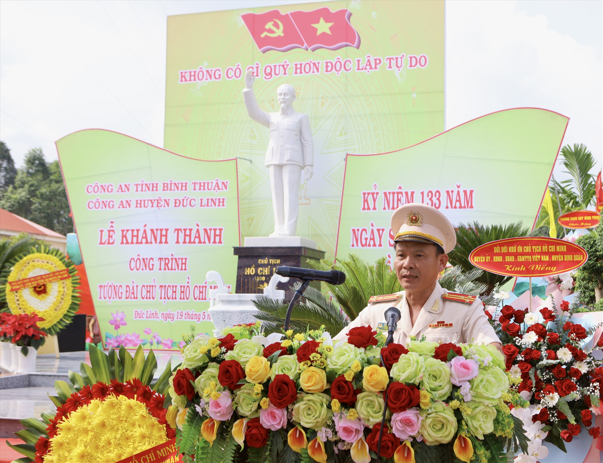 Thượng tá Ung Chiêu Thành, Bí thư Đảng ủy, Trưởng Công an huyện Đức Linh phát biểu báo cáo quá trình xây dựng và khai mạc Lễ khánh thành tượng đài Chủ tịch Hồ Chí Minh. Ảnh: Duy Tuấn