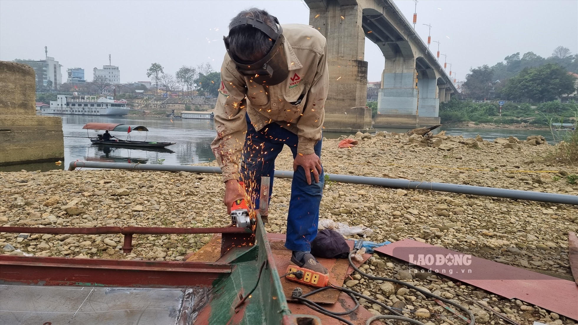 Anh Lê Anh Minh (tổ 4 phường Nông Tiến) bao năm sống bằng nghề nuôi cá trên sông Lô nhưng mấy tháng qua nước sông cạn không thể hạ lồng cá, hiện anh tranh thủ sửa chữa lại thuyền trong thời gian chờ nước.