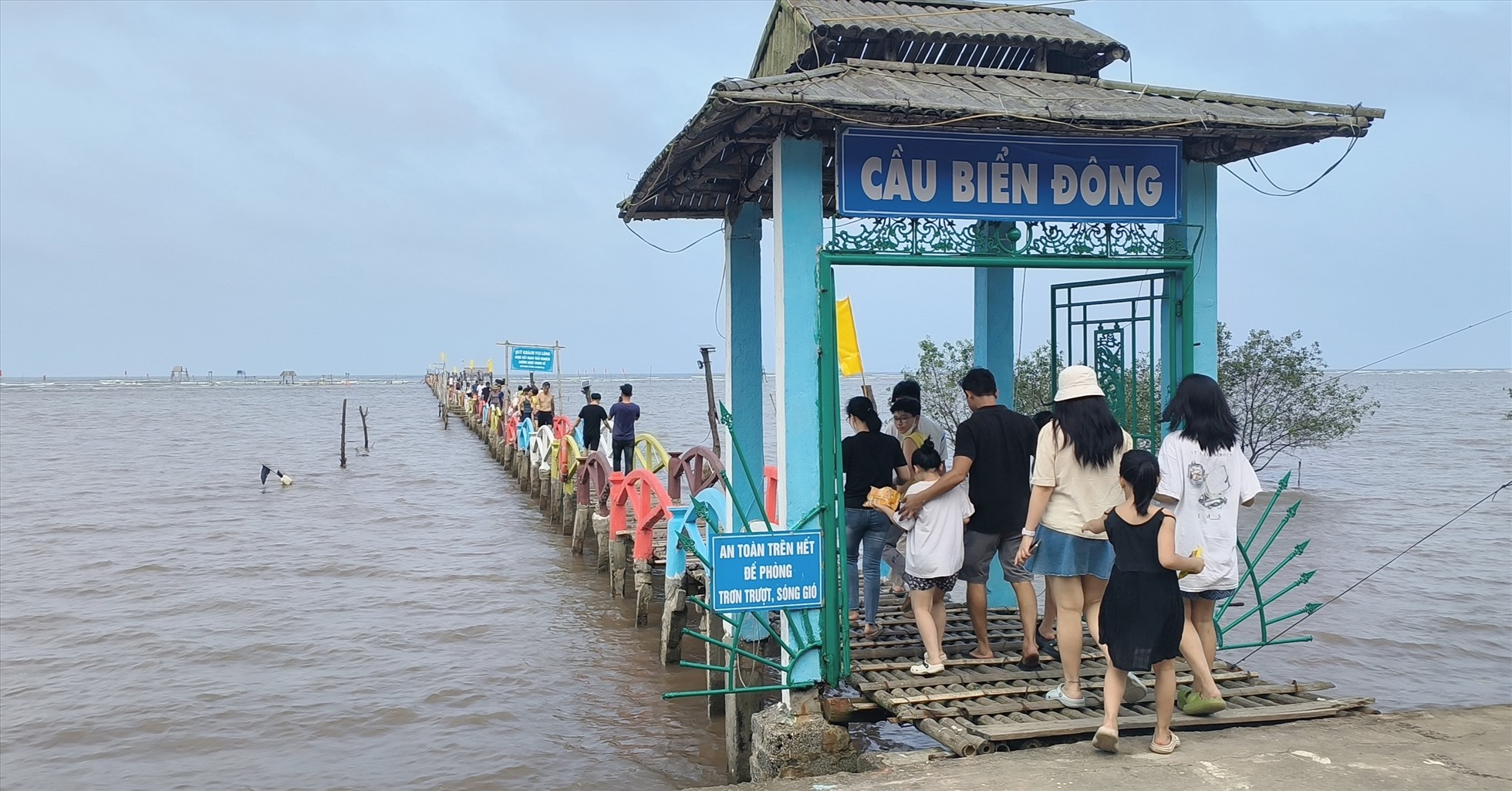 Du khách thích thú trải nghiệm cầu tre Biển Đông ngắm hoàng hôn trên biển Cồn Đen. Ảnh: Trung Du