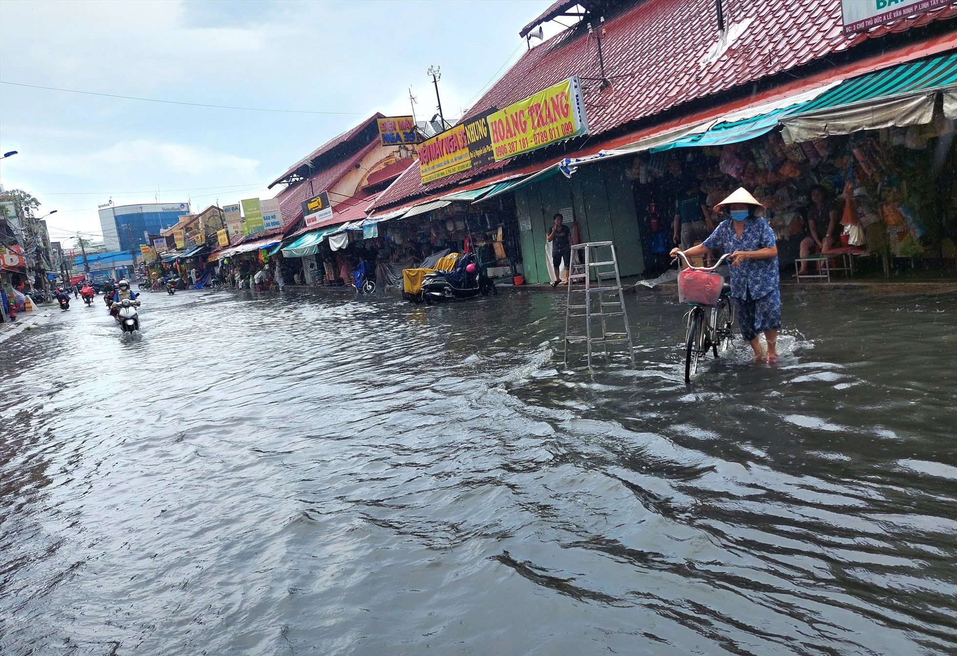 Người dân bì bõm lội nước ngập tại đường Kha Vạn Cân qua chợ Thủ Đức ngày 16.5.  Ảnh: Minh Quân