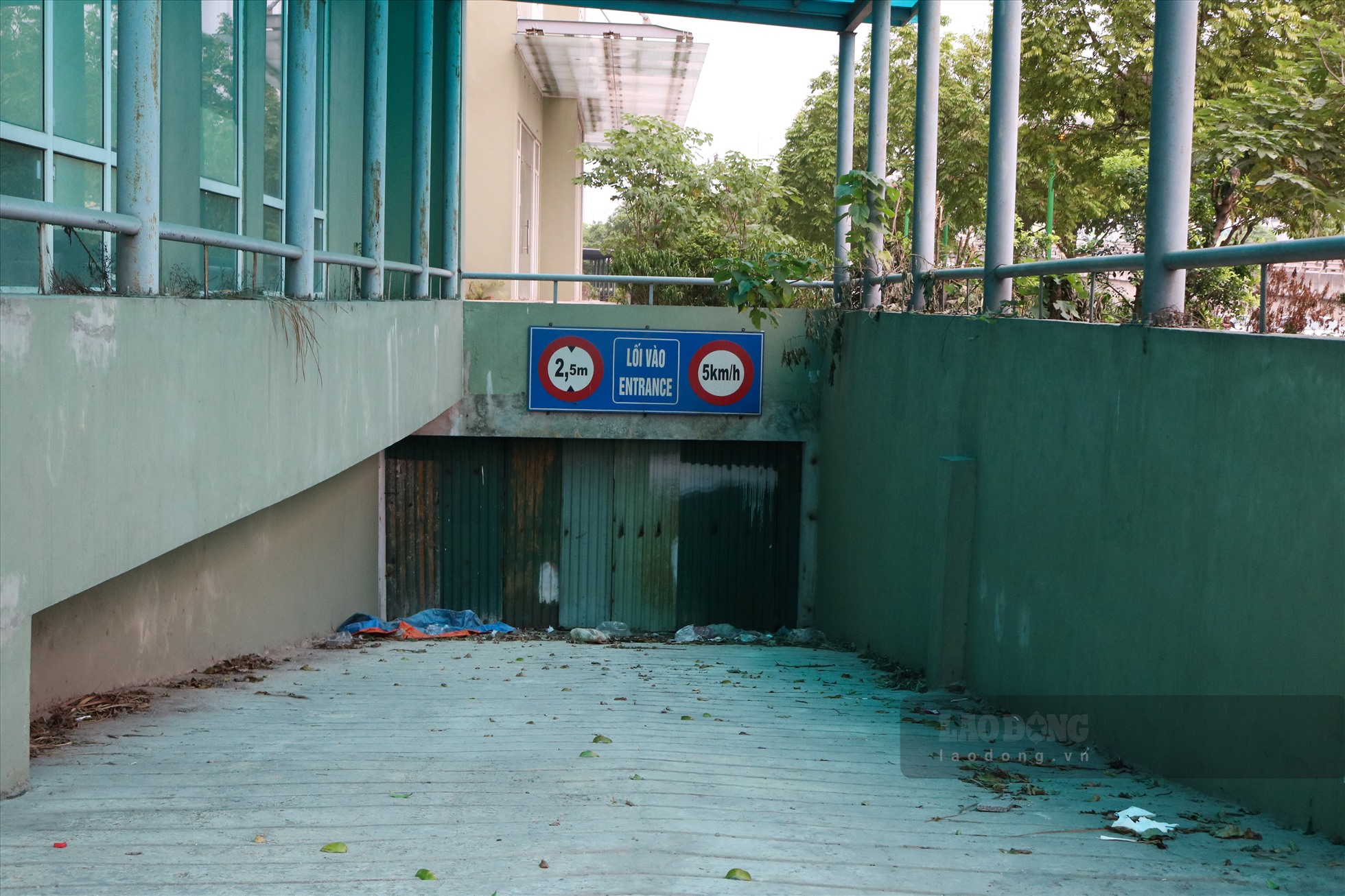 Lối vào các hầm để xe ngập rác thải được che kín bằng tôn.