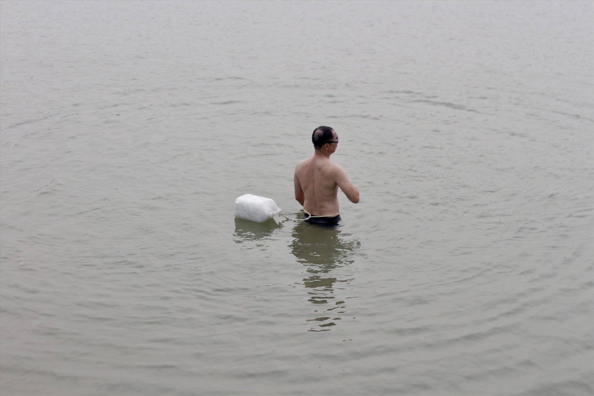 Người dân đi bơi chỉ mang theo can nhựa để làm “phao cứu sinh”. Ảnh: Minh Hồng