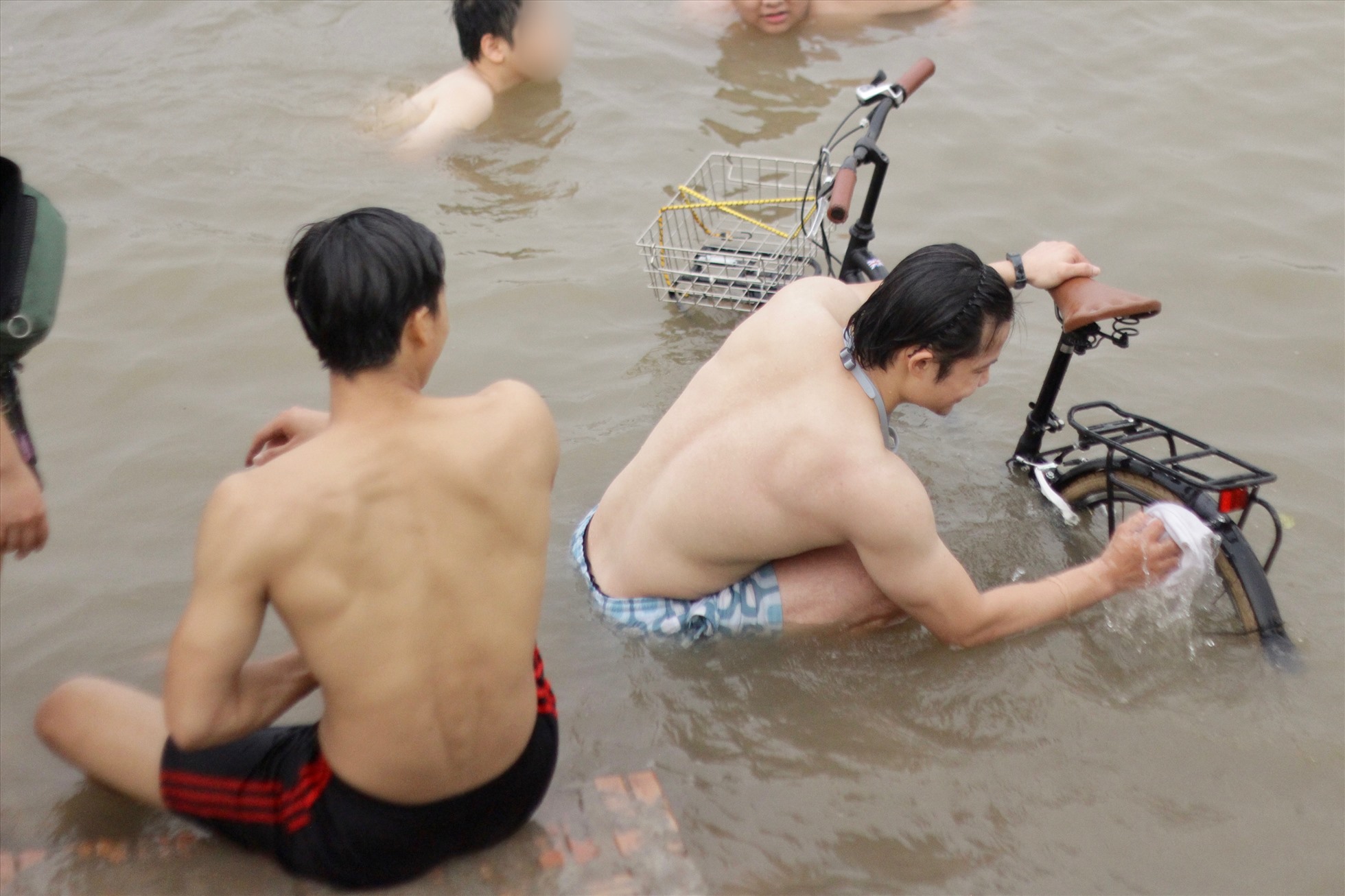 Người dân “tắm xe” ở bãi tắm tự phát. Ảnh: Minh Hồng