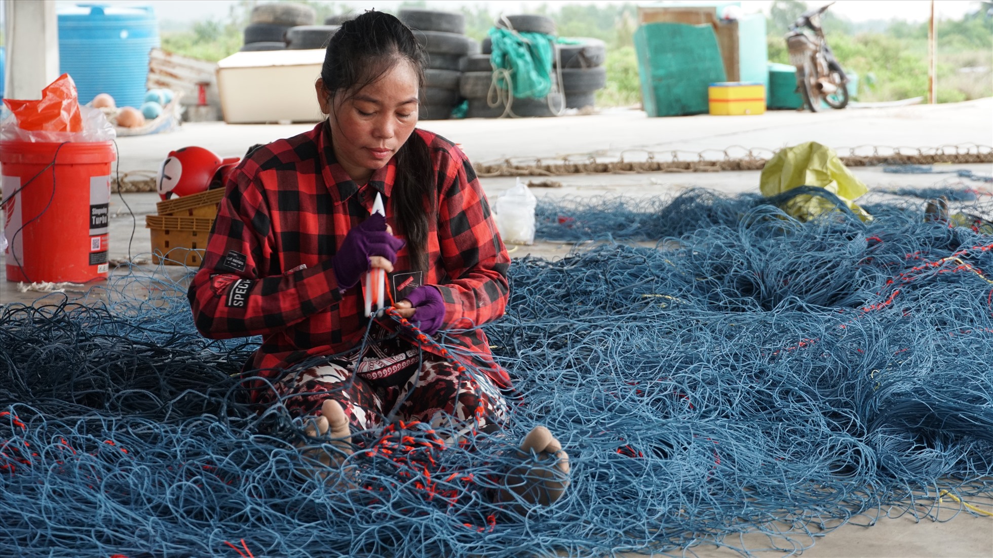 Công việc đan, vá lưới thuê đã tạo việc làm cho chị em phụ nữ trên địa bàn. Ảnh: Bích Ngọc