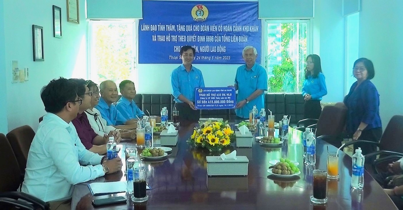 Chủ tịch LĐLĐ tỉnh An Giang Nguyễn Thiện Phú trao bảng tượng trưng 433 suất hỗ trợ đoàn viên, người lao động Công ty NXK Thủy sản An Mỹ. Ảnh: Cẩm Tú