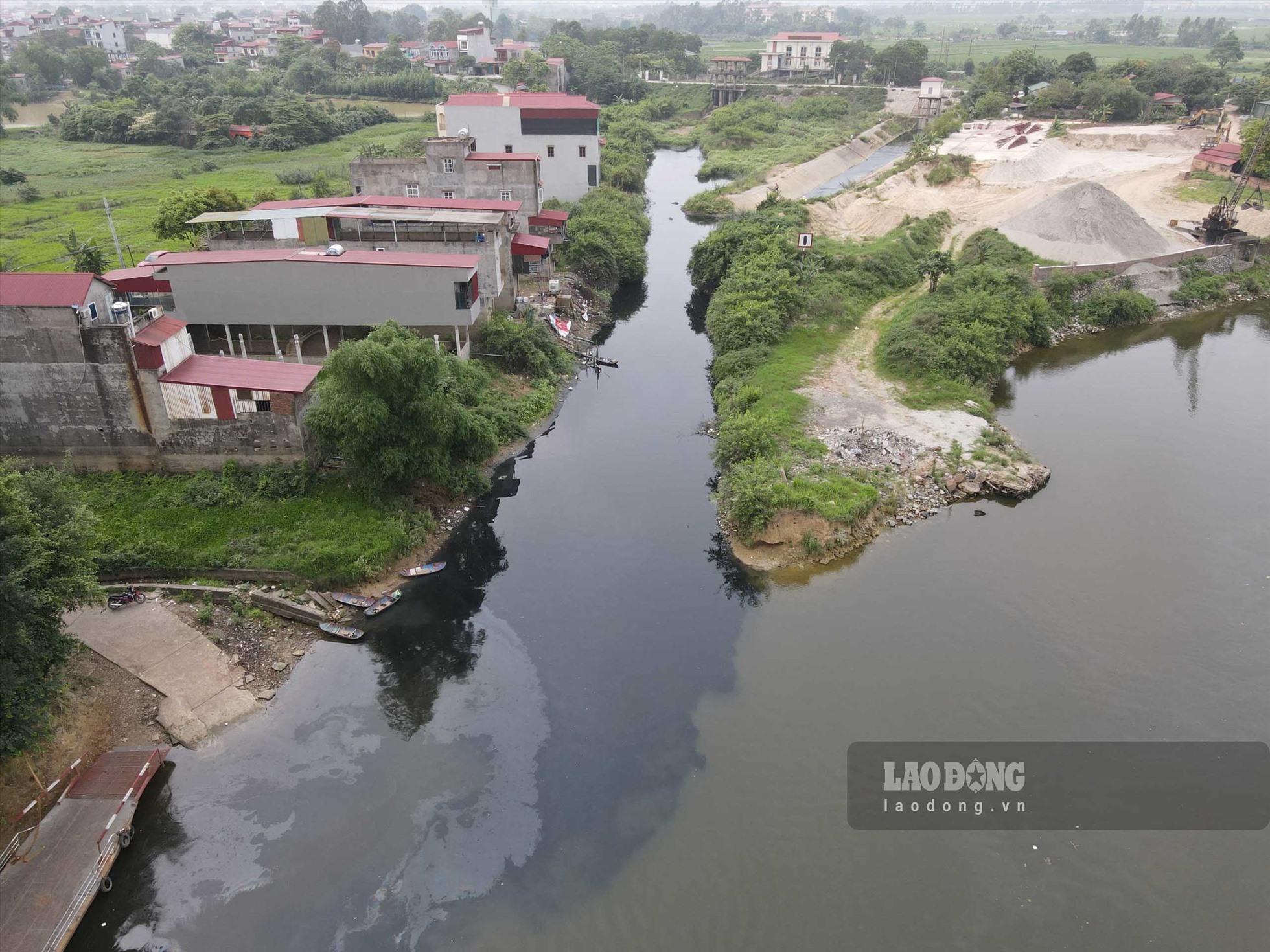 Bằng mắt thường có thể thấy rõ dòng nước thải đen kịt từ cống Vạn An chảy ra sông Cầu thời điểm cuối tháng 4.2023. Ảnh: Trần Tuấn