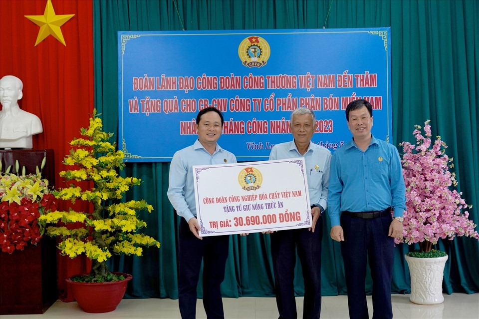 Ông Nguyễn Huy Thông - Chủ tịch Công đoàn công nghiệp Hóa chất Việt Nam (ngoài cùng trên trái) trao hỗ trợ mua tủ làm ấm thức ăn cho đại diện công nhân. Ảnh: Công đoàn Công Thương VN