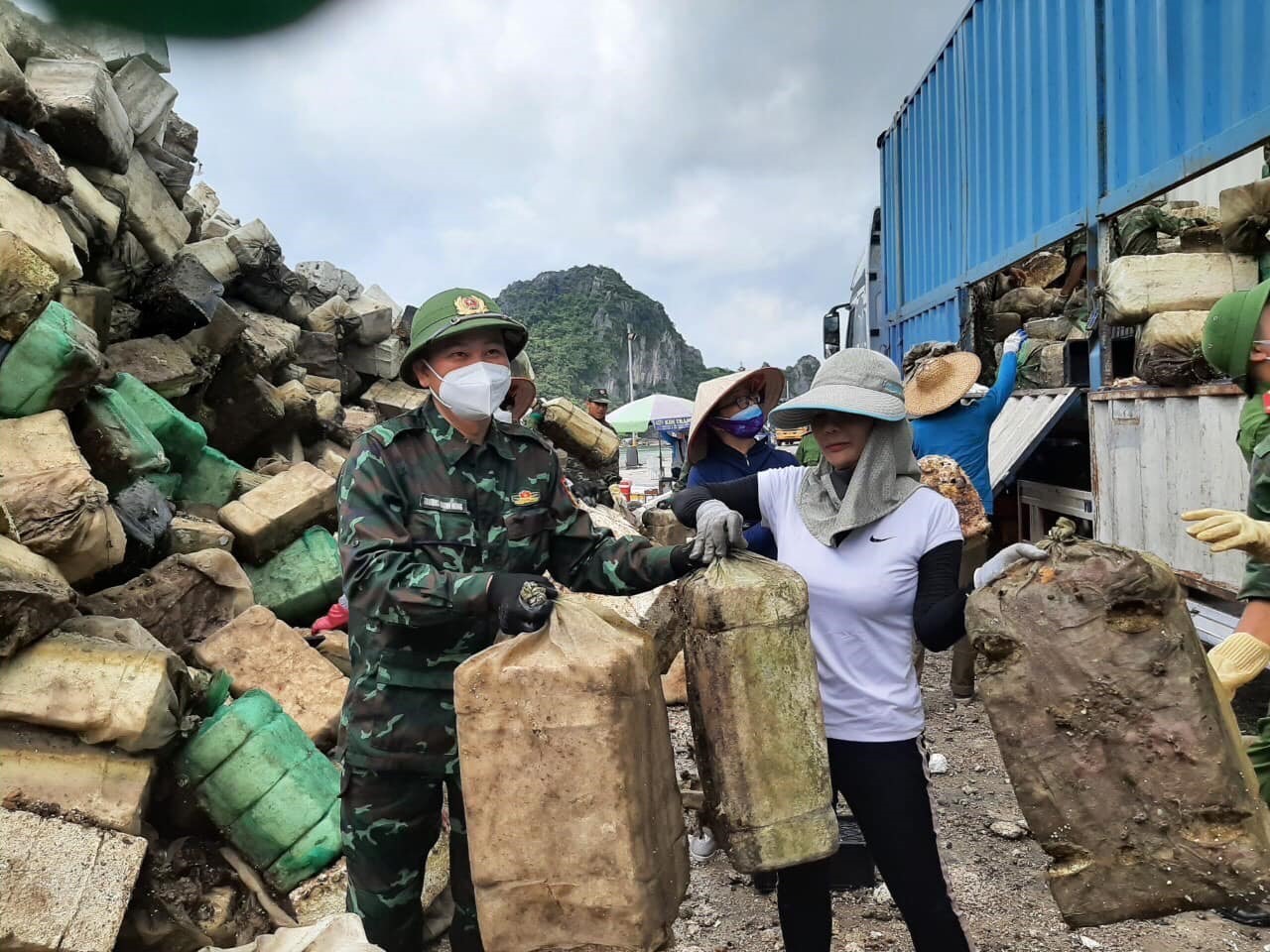 Bí thư huyện ủy Vân Đồn Trương Mạnh Hùng tham gia đưa rác lên xe sáng 27.5.2023. Ảnh: Nguyễn Hùng
