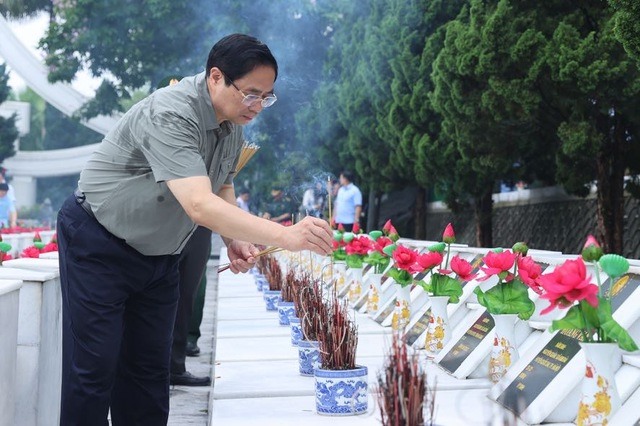 Thủ tướng Phạm Minh Chính thắp hương các phần mộ liệt sĩ. Ảnh: VGP