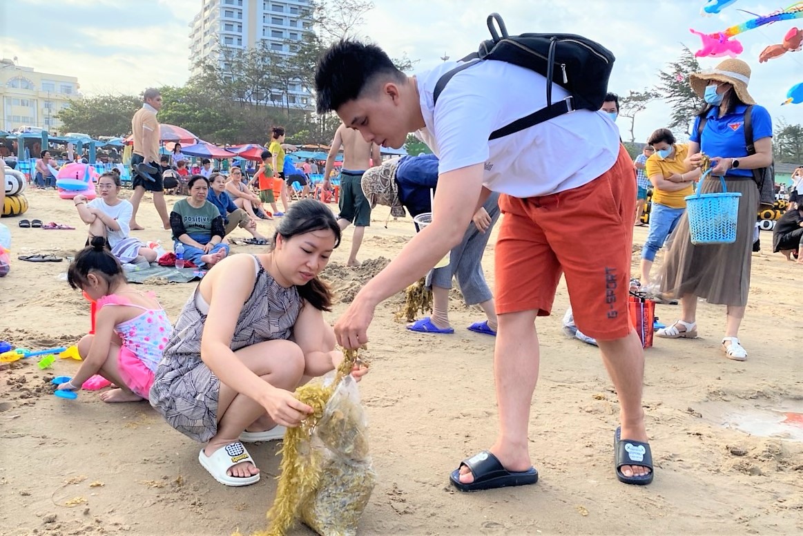Gia đình du khách Gia Huy  (Quận 11, TP Hồ Chí Minh) tham gia làm sạch bãi biển cùng chính quyền địa phương. Ảnh: Kê Hoàng