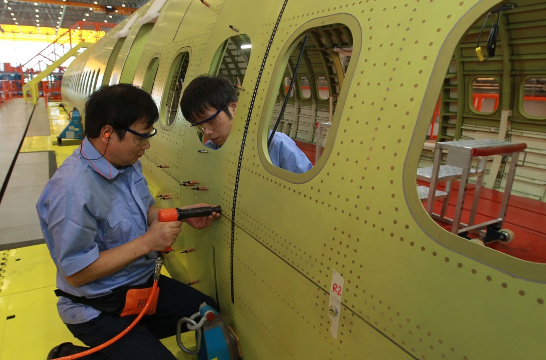 Kỹ thuật viên lắp đinh tán trên thân máy bay C919 tại cơ sở lắp ráp của Comac tại Thượng Hải, tháng 9.2014. Ảnh: Xinhua
