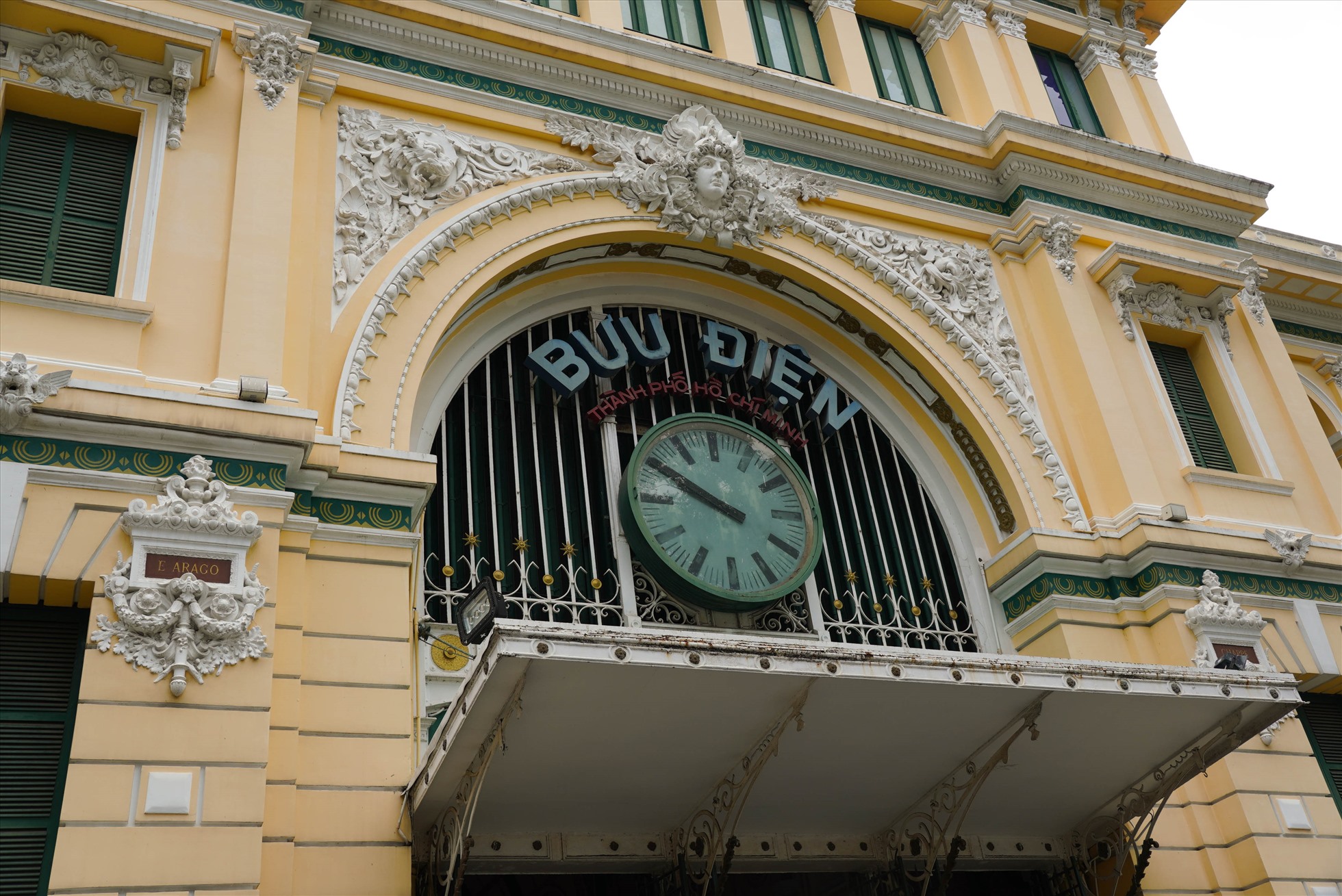 Cửa chính ra vào tòa nhà thiết kế vòm cung đặc trưng, với chiếc đồng hồ lớn ở giữa. Phía trên có tượng đắp nổi điêu khắc hình người đội vòng nguyệt quế và hàng chữ “Bưu điện Thành phố Hồ Chí Minh“, phía dưới đề năm xây dựng và khánh thành bưu điện “1886-1891“.