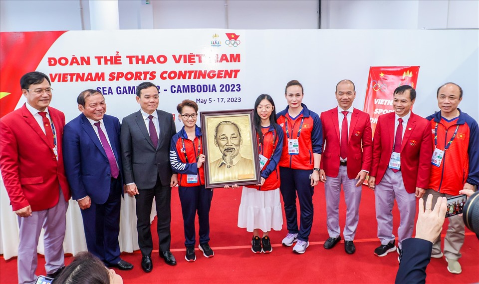 Hai nữ kỳ thủ cờ ốc Việt Nam Hồng Ân và Phương Thảo nhận tranh  Chủ tịch Hồ Chí Minh từ đoàn công tác gửi tặng cho đoàn thể thao Việt Nam.