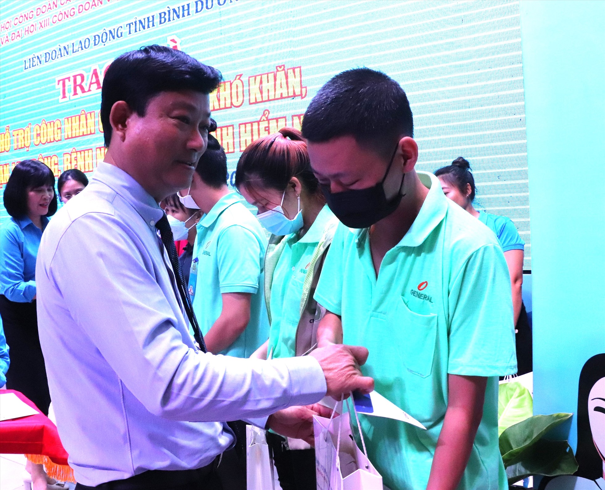 Ông Võ Văn Minh - Chủ tịch UBND tỉnh  Bình Dương trao quà hỗ trợ công nhân.Ảnh: Đình Trọng