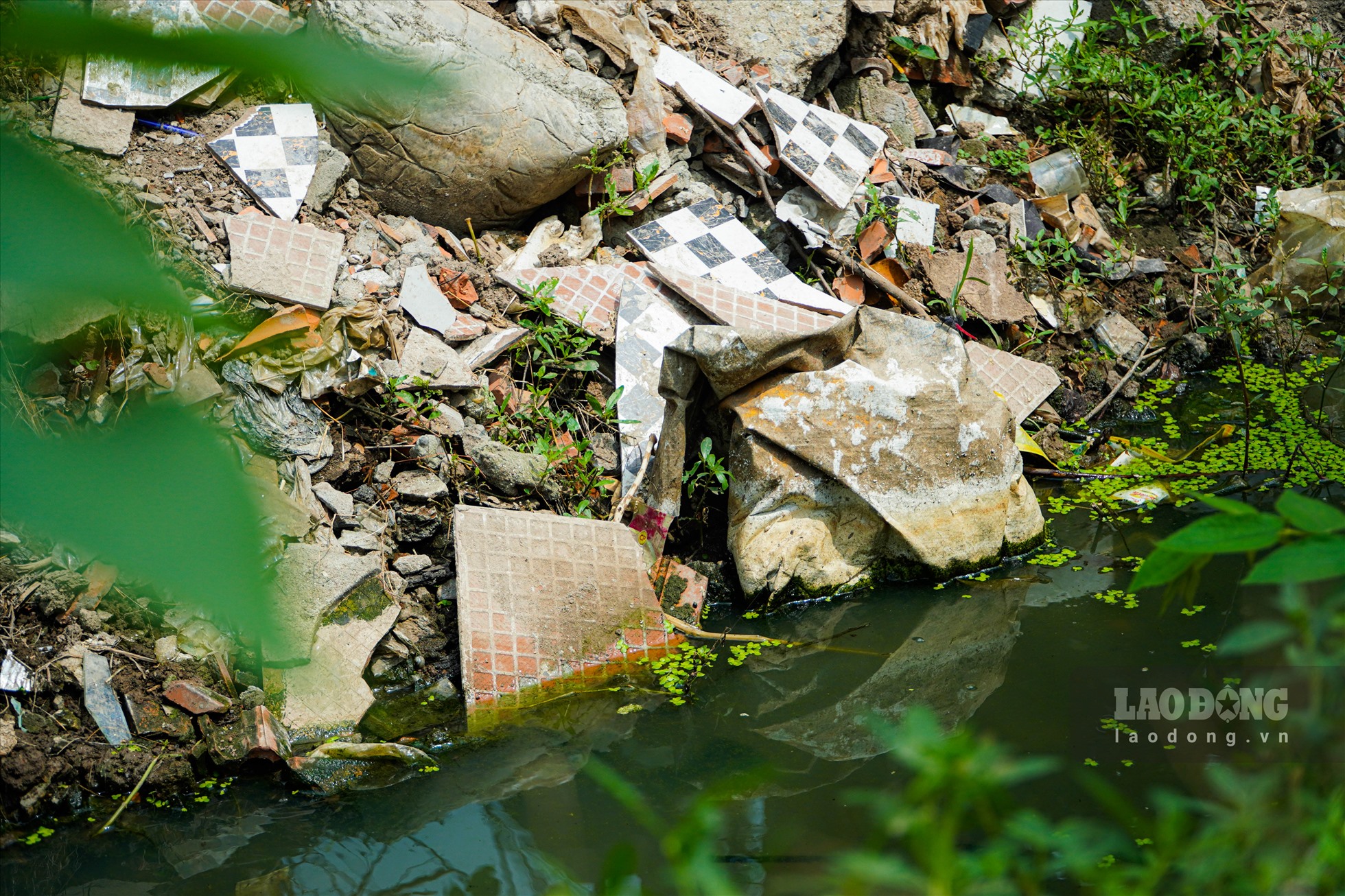 Tại con mương thoát nước trải dài hơn 100 mét nằm trong ngõ 115 phố Trần Cung (Cầu Giấy), các loại rác thải sinh hoạt, rác thải xây dựng, phế thải vứt đầy  hai bên bờ  mương.