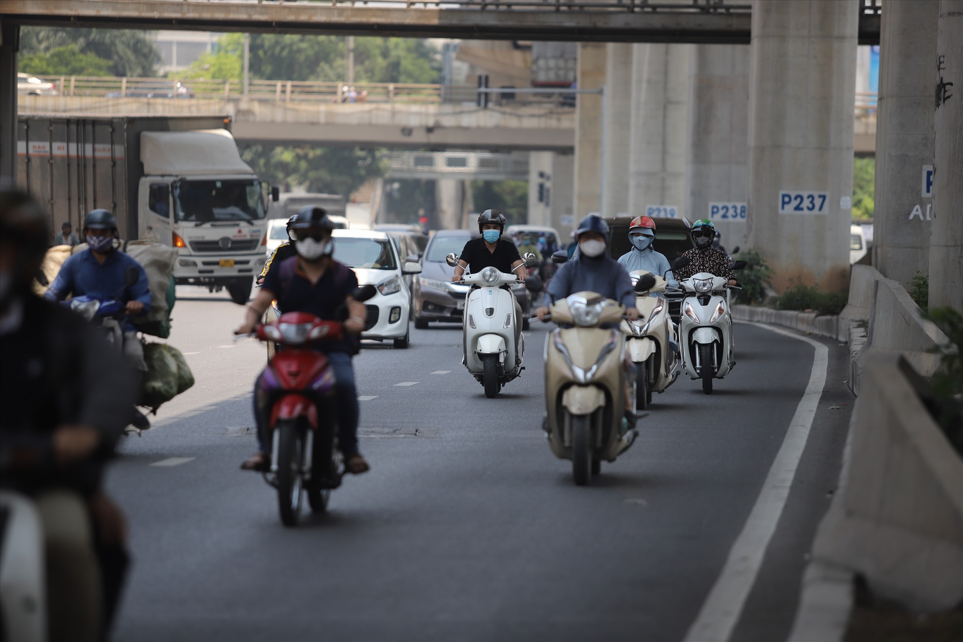 Các phương tiện xe máy đi vào làn đường phía dưới đường sắt đô thị Nhổn - ga Hà Nội để tránh nắng.