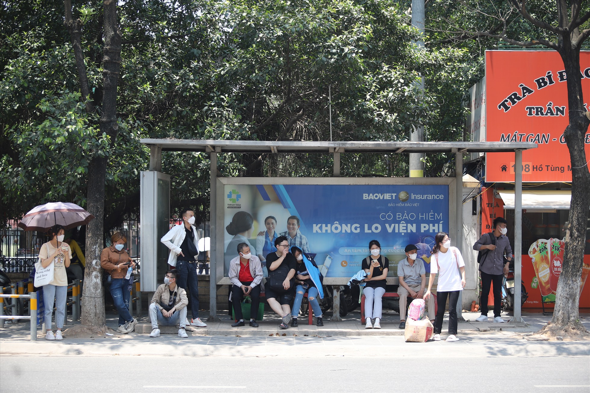 Người dân chờ xe buýt dưới thời tiết nắng nóng gay gắt.