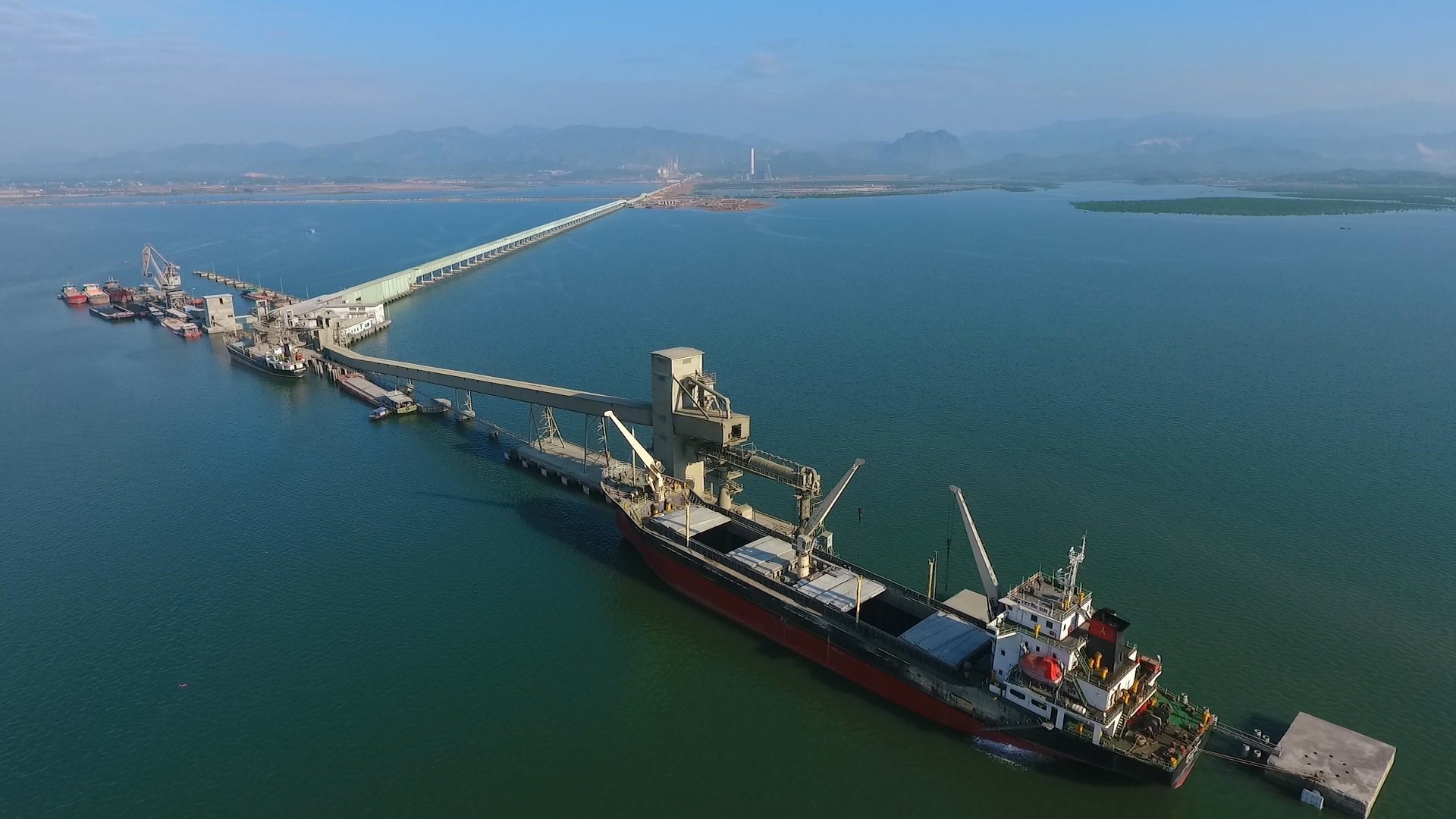 Đường băng tải dài hàng km vươn ra giữa vịnh Cửa Lục của một nhà máy xi măng bên bờ vịnh Cửa Lục. Ảnh: Nguyễn Hùng