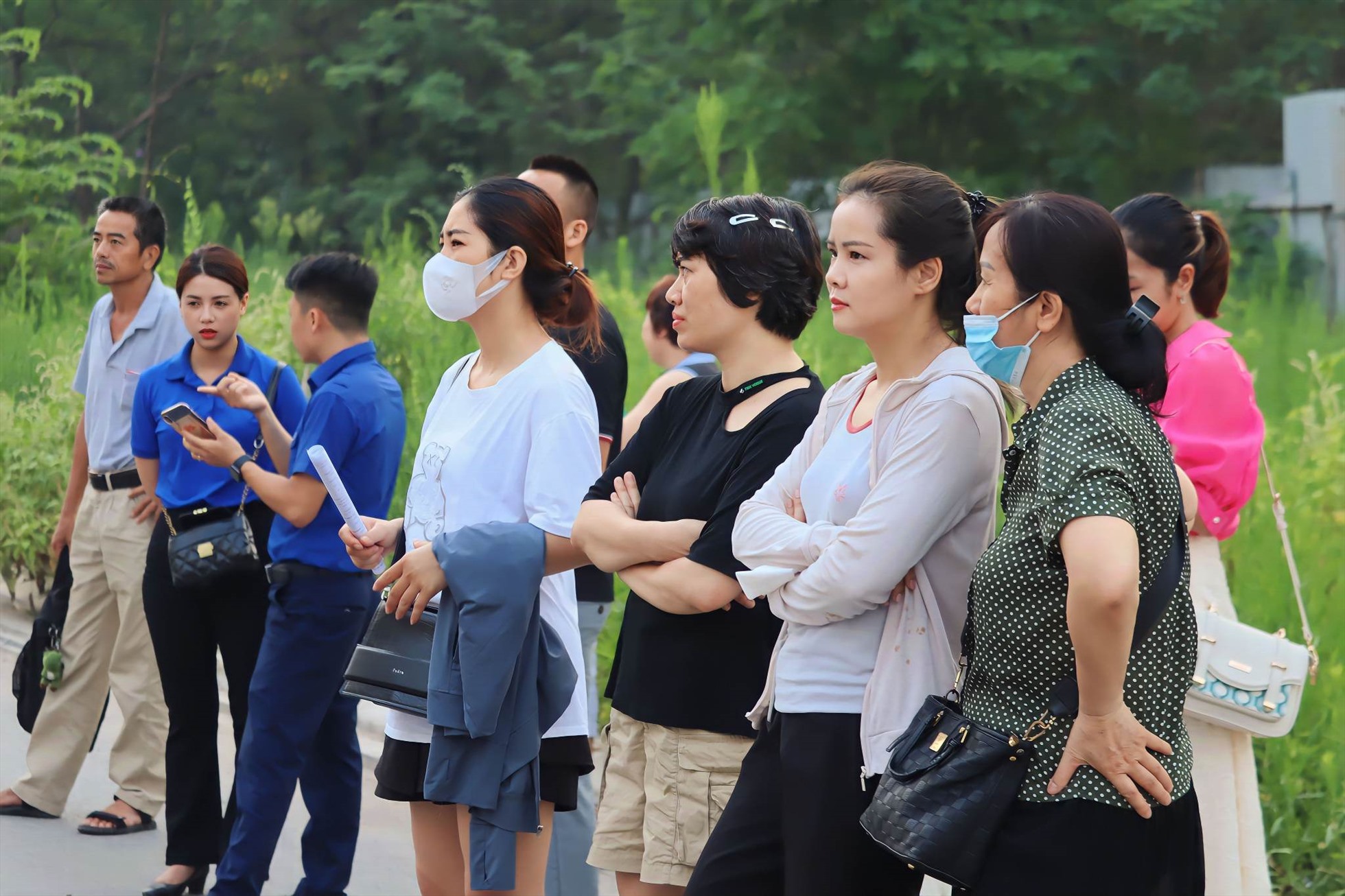 Mặc dù thí sinh đã vào phòng thi nhưng nhiều phụ huynh vẫn đứng ở ngoài cổng trường, ngóng theo con.