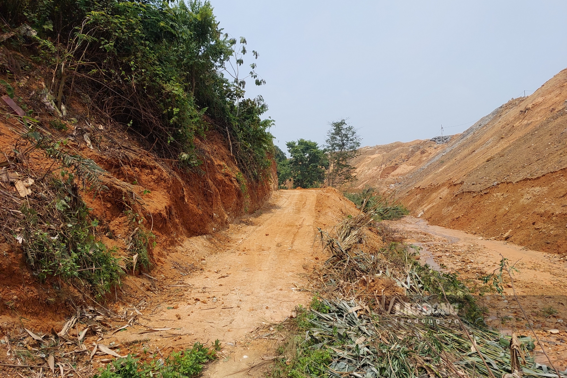 Đường bê tông đã bị chôn vùi, đơn vị thi công KCN Cẩm Khê làm tạm 1 con đường khác cho gia đình ông Hạnh. Ảnh: Tô Công.
