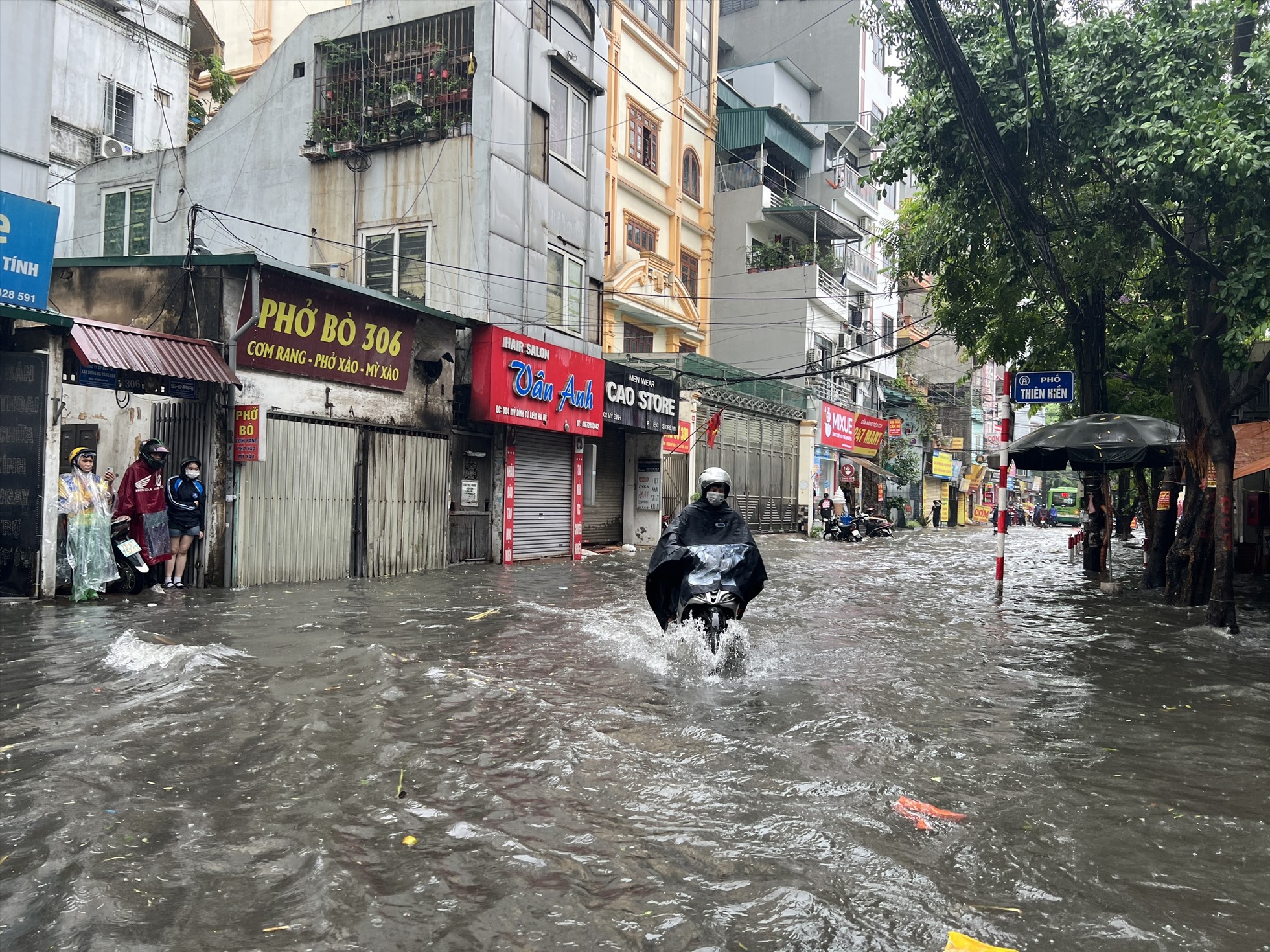 Theo ghi nhận, trận mưa lớn xảy ra vào trưa 12.6 khiến nhiều tuyến phố của Hà Nội như: Mỹ Đình, Thiên Hiền, Trần Bình, Hoàng Văn Thái,… bị ngập sâu trong nước.