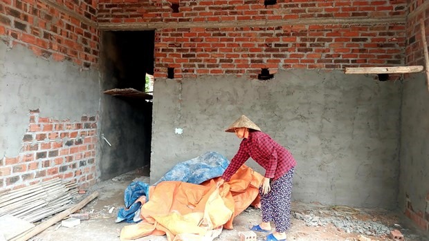 Bà Phạm Thị Nương (72 tuổi) xã An Sinh, thị xã Đông Triều vui mừng khi ngôi nhà “3 cứng” sắp hoàn thiện. Ảnh: TTXVN