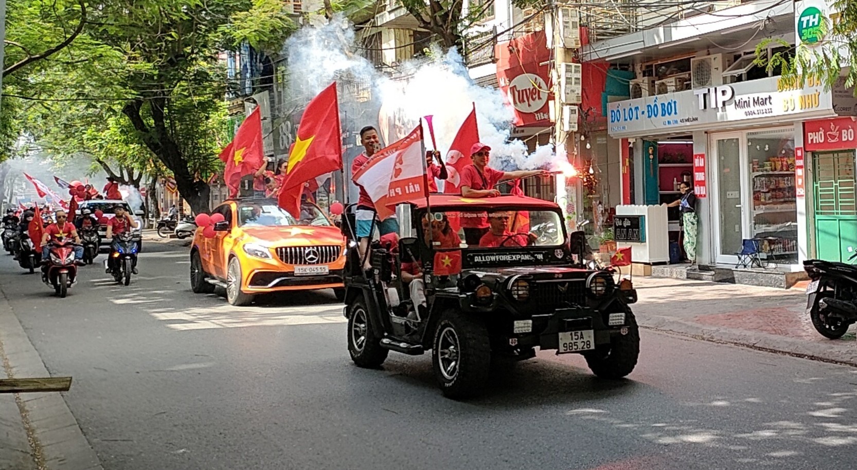 Nhiều cổ động viên đốt pháo sáng khi diễu hành qua tuyến phố Mê Linh (quận Lê Chân). Ảnh: Hoàng Khôi