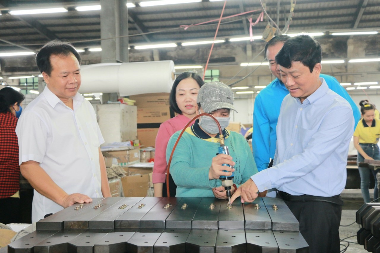 Ông Võ Văn Minh - Chủ tịch UBND tỉnh Bình Dương (bìa phải) đia thăm động viên công nhân và doanh nghiệp gặp khó khăn. Ảnh: Hoàng Trung