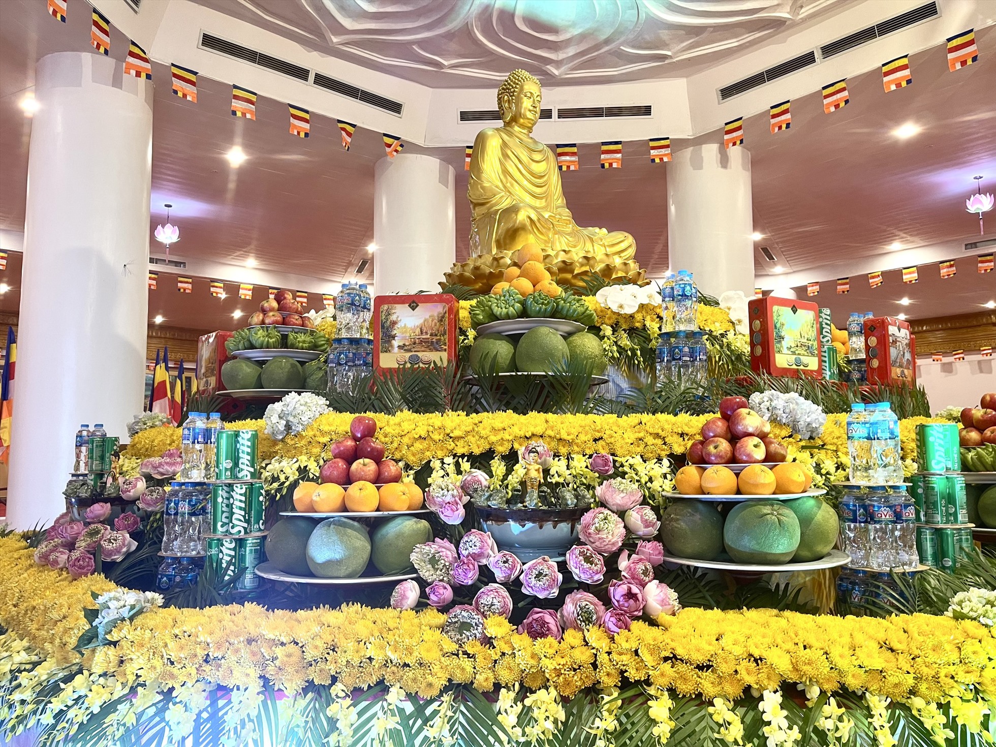 Hoa cúc và sen tươi được trang hoàng rạng rỡ trong lòng Đại Tượng Phật mừng đón Phật đản. Ảnh: Hà