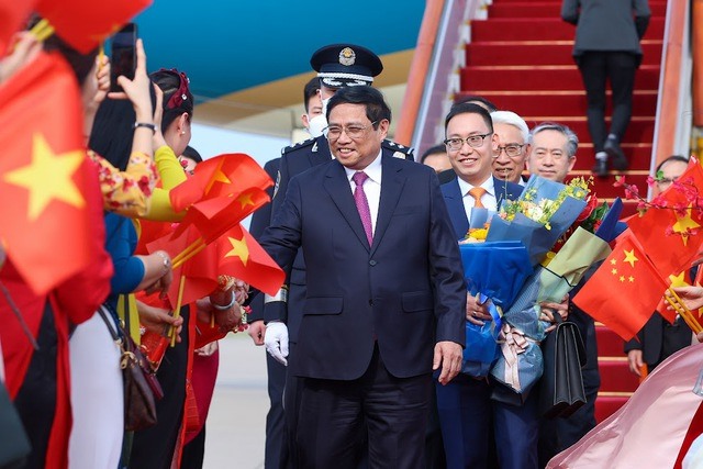 Cán bộ, nhân viên Đại sứ quán Việt Nam và đại diện cộng đồng Việt Nam tại Trung Quốc chào đón Thủ tướng Chính phủ Phạm Minh Chính và đoàn đại biểu Việt Nam. Ảnh: VGP